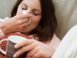Woman with tissue and hot drink